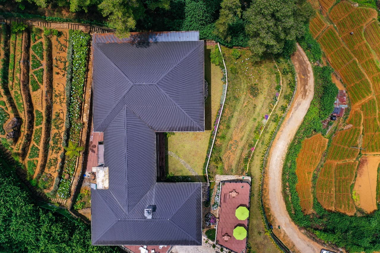 Wide aerial view of hotel surrounded by green hills